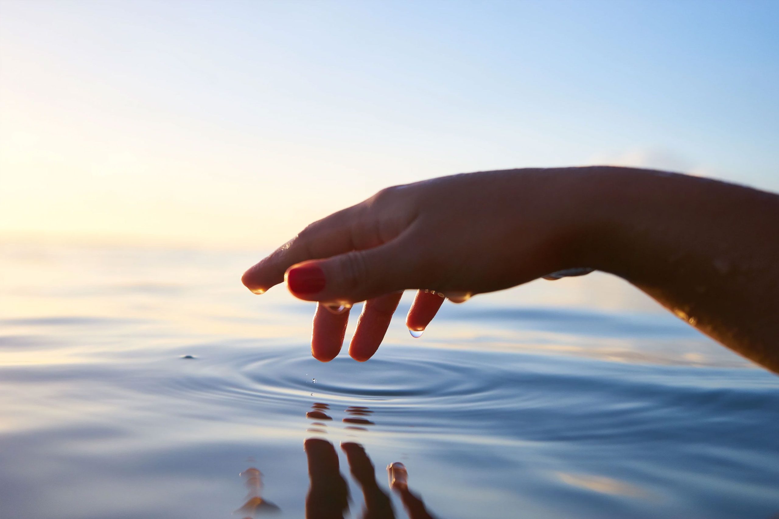Hand Hovering Above Water Hand Touching Water